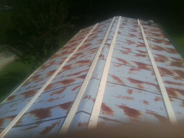 Rusted metal roof panels with new wood purlins before replacement — Storm Damage Roof Repair in Boomer by Roofing Brothers