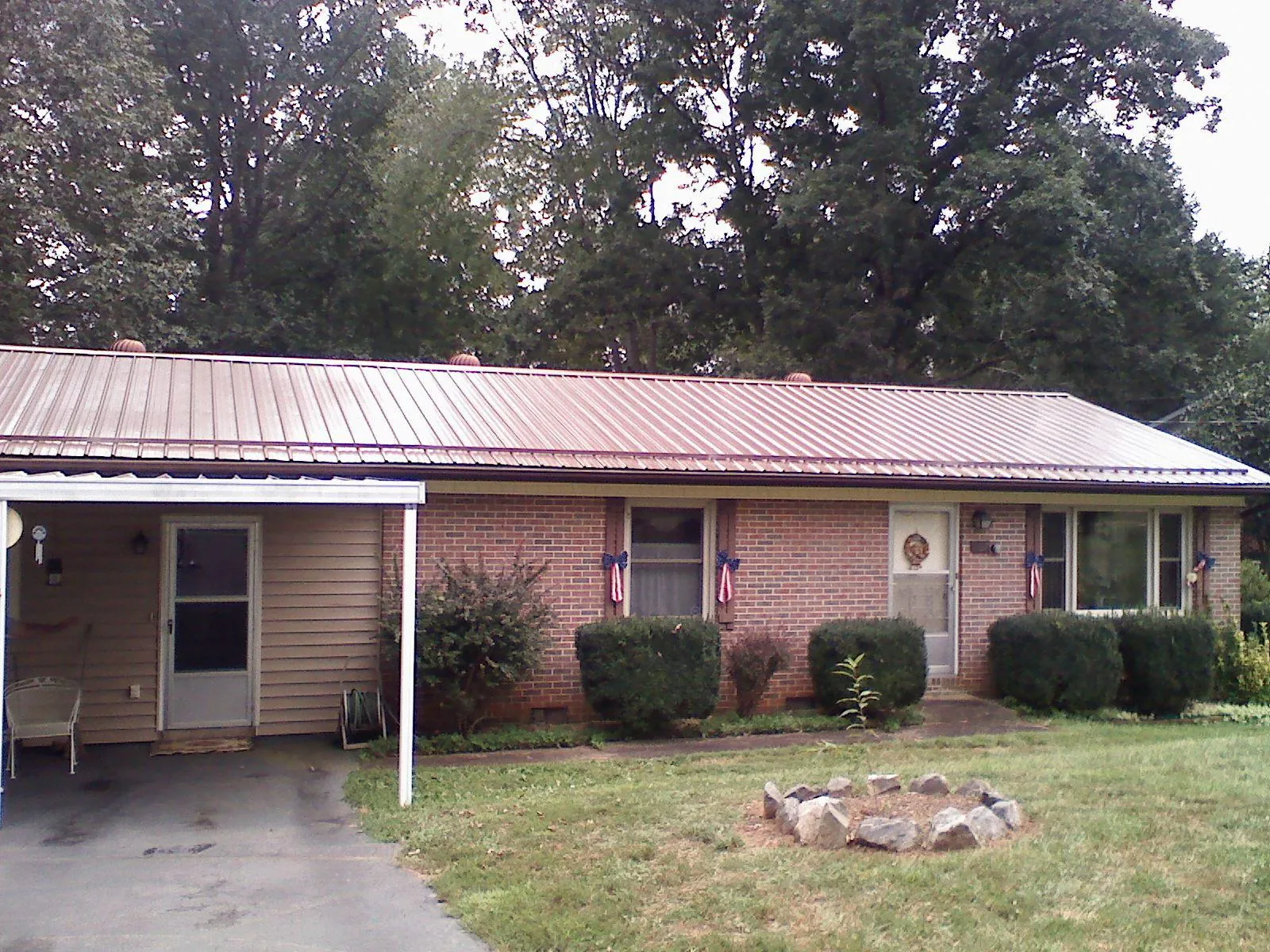 Bronze metal roof and carport on a brick ranch home — Roof Repair work by our crew in Boomer